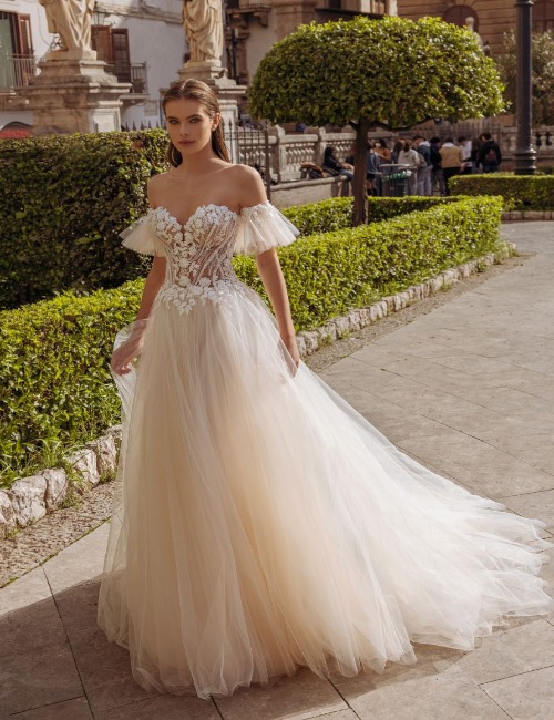 De elegante trouwjurk Sharon van het merk Modeca, met schattige kanten details en een prachtige A-lijn rok die de rondingen van de bruid benadrukt.